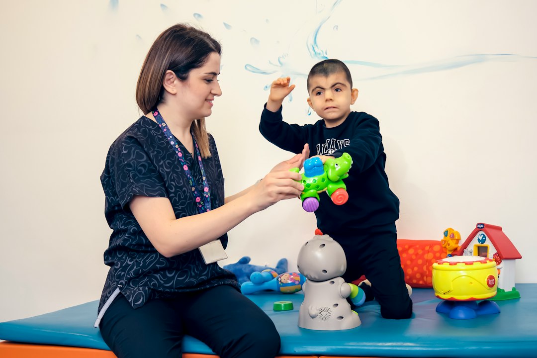 Therapist helping child with developmental activity in welcoming clinic
