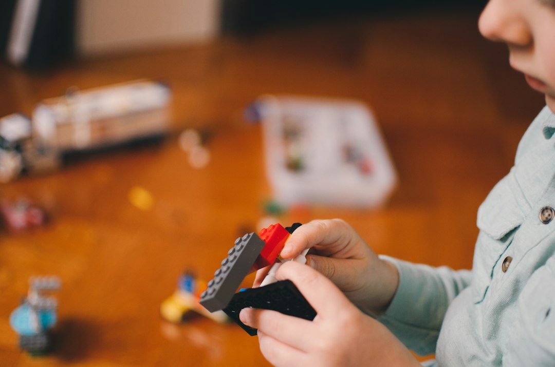 Child practicing fine motor skills with building blocks