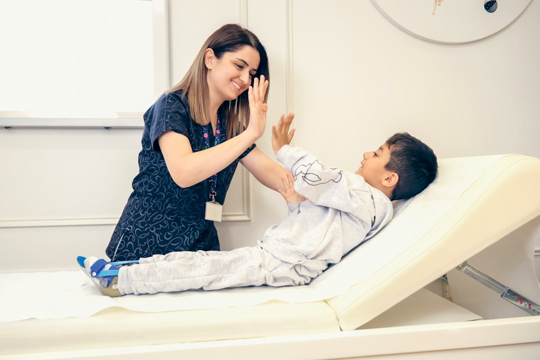 Therapist collaborating warmly with a child and caregiver in consultation room